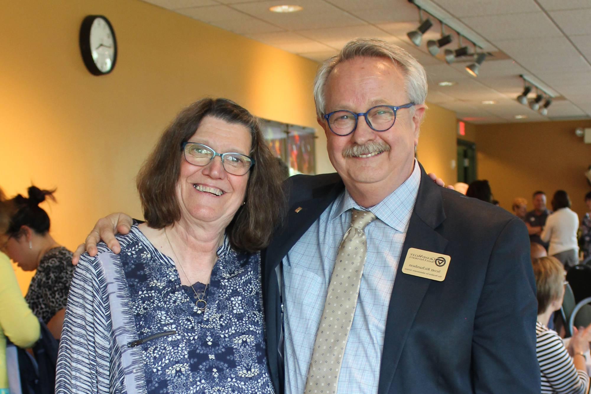 两个GVSU退休人员的照片, 斯科特·理查森和邦妮·玛卡, 他们拥抱在一起微笑着